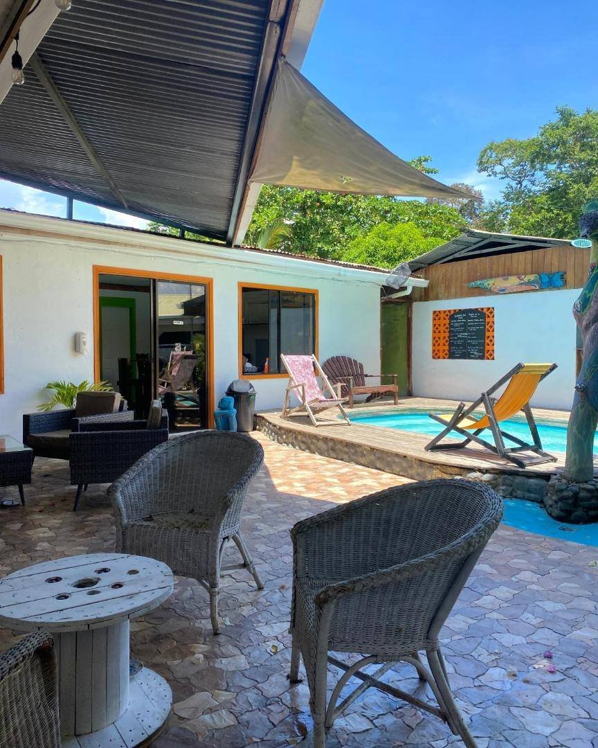 Cabinas Cahuita: patio with wicker chairs next to the pool